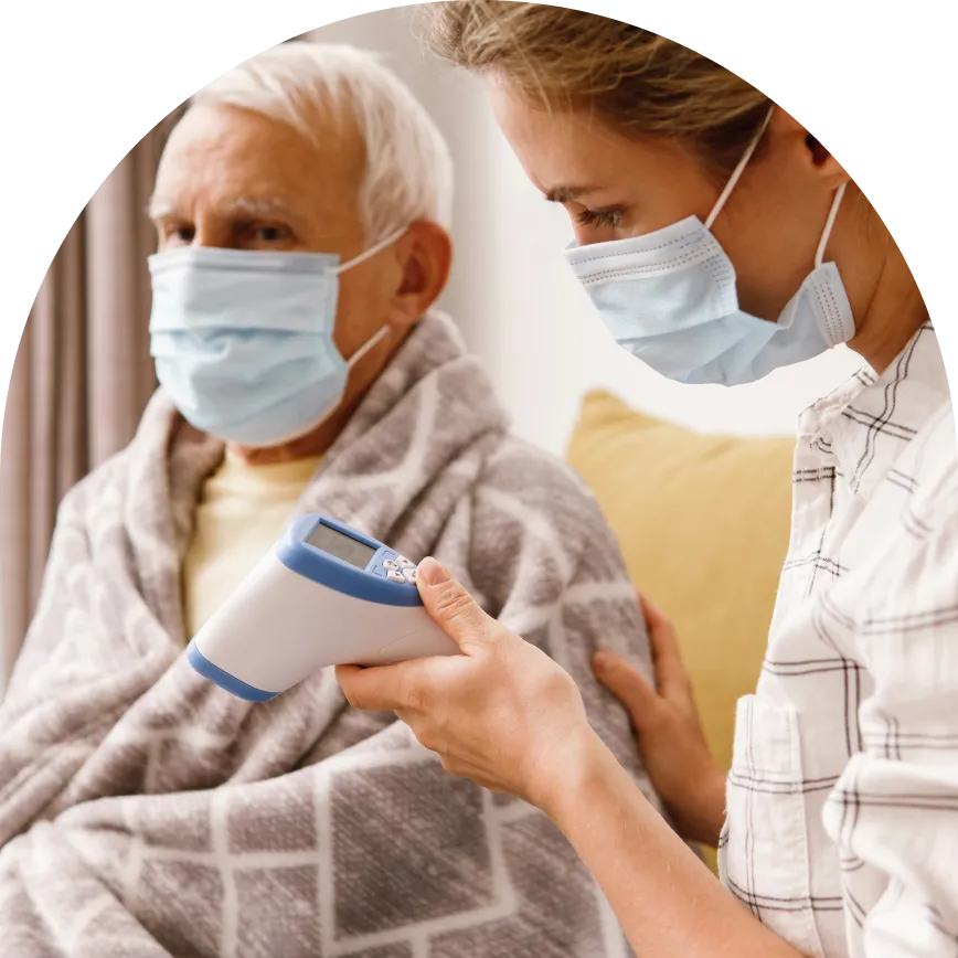 a man and woman wearing face masks while using a thermometer