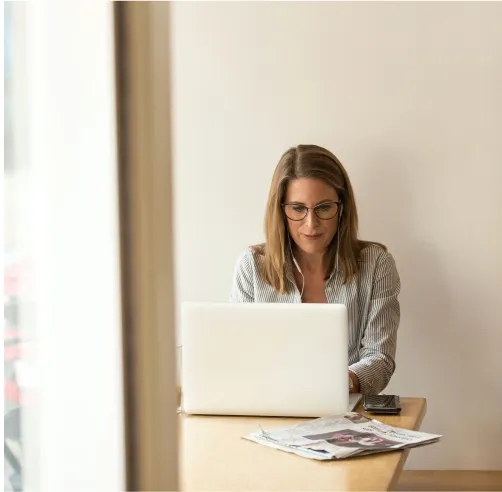 a woman sitting at a table using a laptop computer