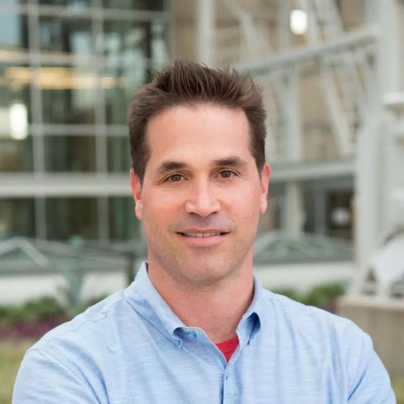 a man in a blue shirt is posing for a picture